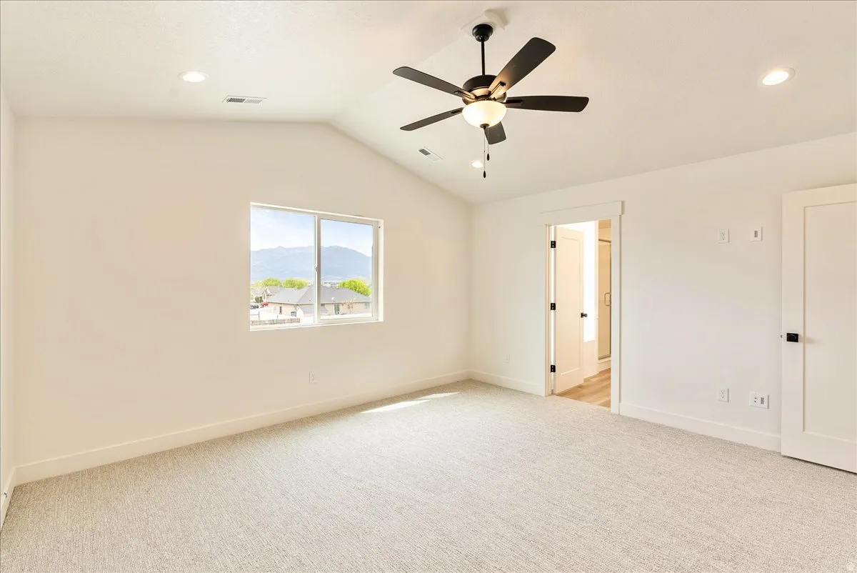 Empty room featuring light colored carpet, recessed lighting, ceiling fan, and a mountain view