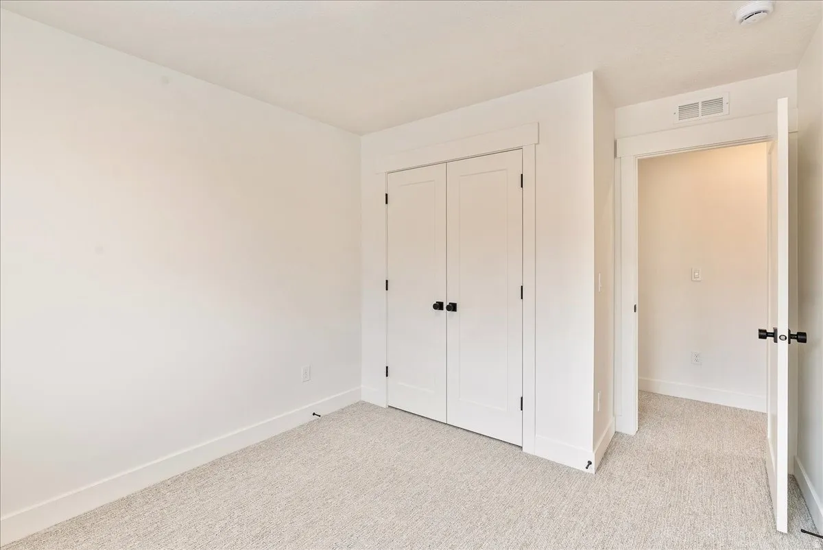 Unfurnished bedroom with light colored carpet and a closet