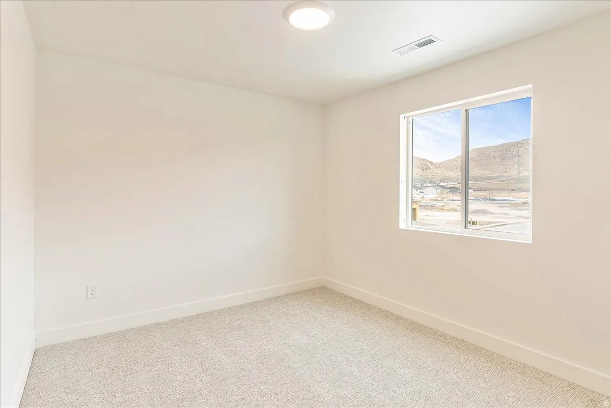 Spare room featuring light carpet and a mountain view