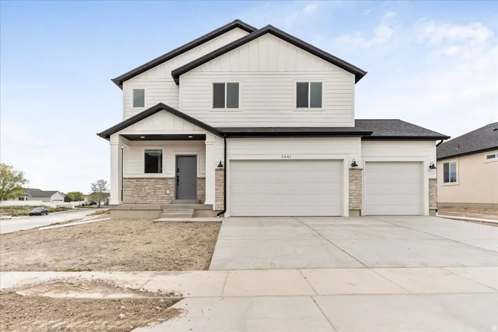 View of front facade with board and batten siding, stone siding, concrete driveway, an attached garage, and a shingled roof