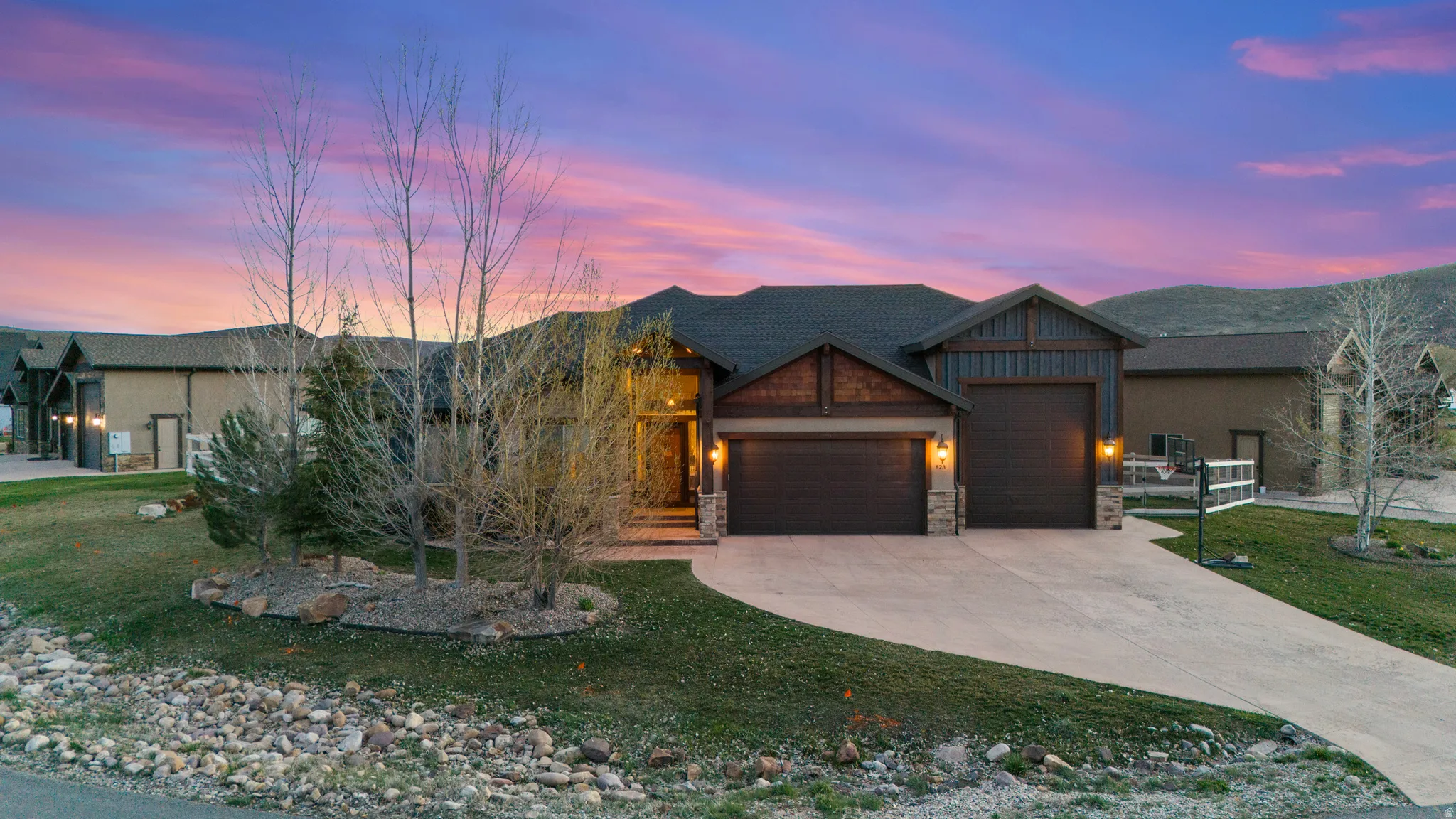 Craftsman inspired home with stone siding, an attached garage, a lawn, and concrete driveway