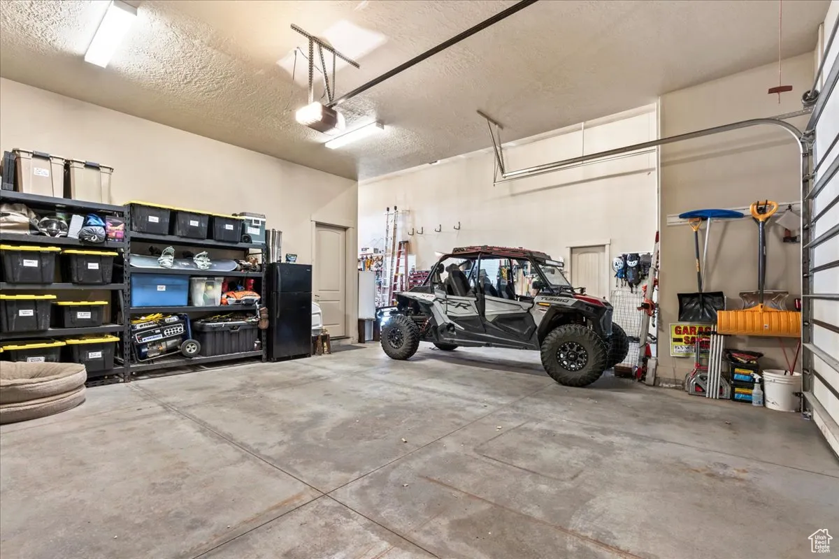 Garage with a garage door opener, two cars fit with the side-by-side between the RV bay and car bay.