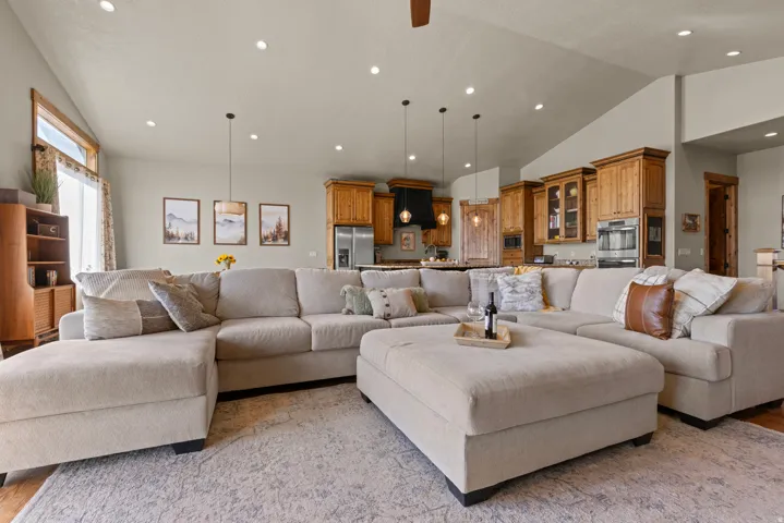 Living area with lofted ceiling, light wood-style flooring, recessed lighting, and ceiling fan