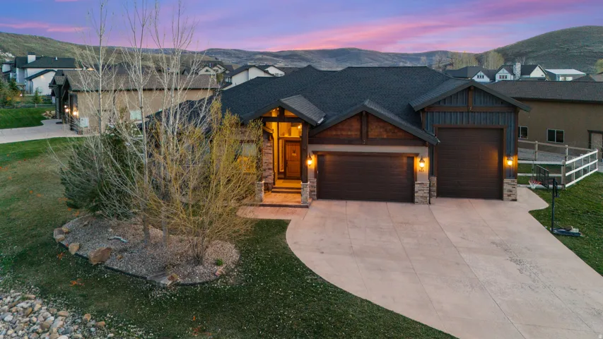 View of front of property with a garage, stone siding, driveway, and a mountain view
