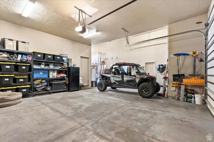 Garage with a garage door opener, two cars fit with the side-by-side between the RV bay and car bay.