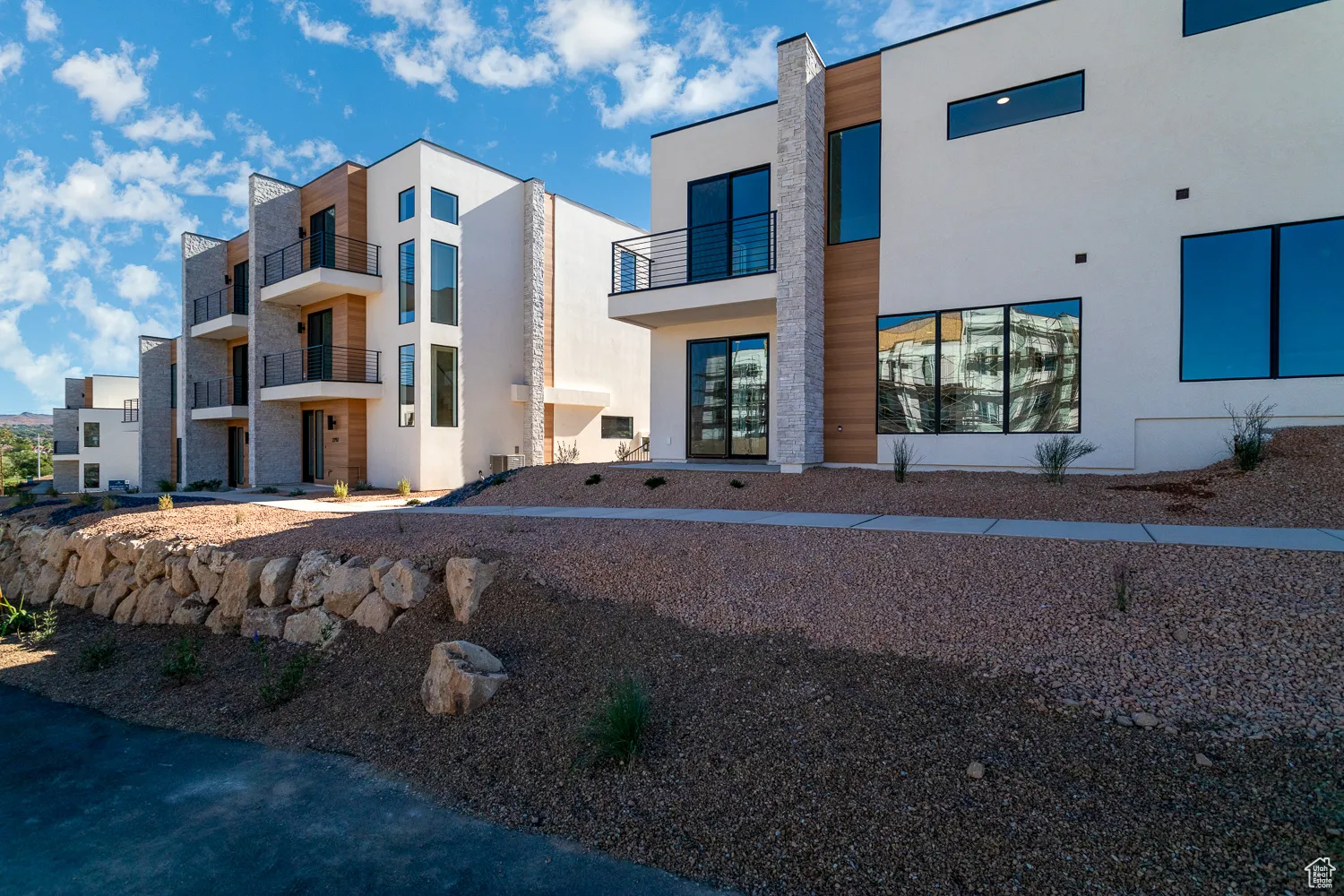 Rear view of property with stucco siding and a balcony