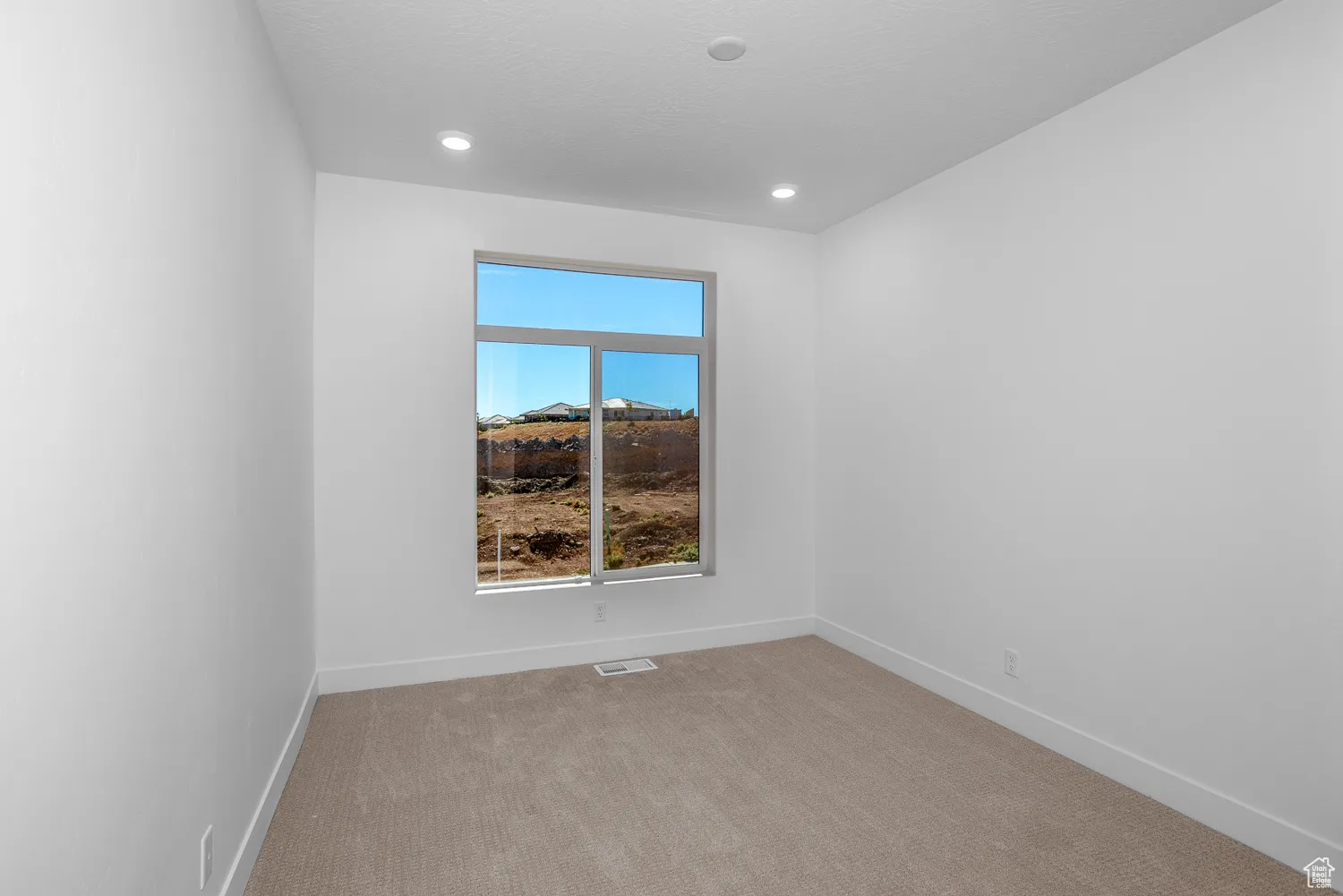 Empty room featuring light colored carpet and recessed lighting