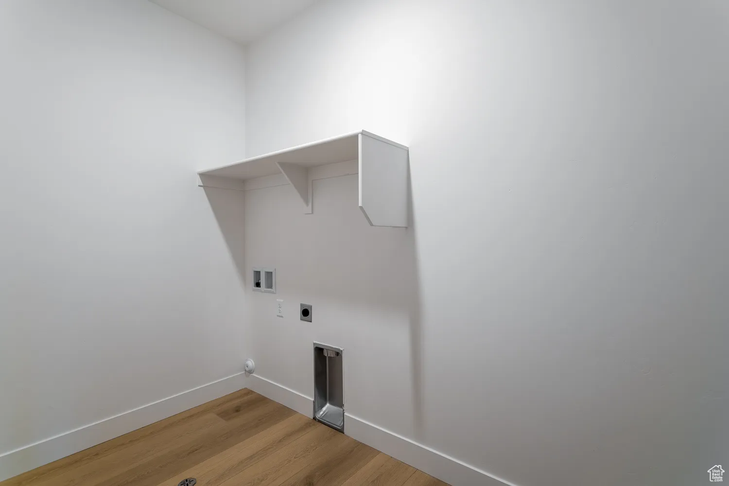 Washroom with light wood finished floors, hookup for an electric dryer, and washer hookup