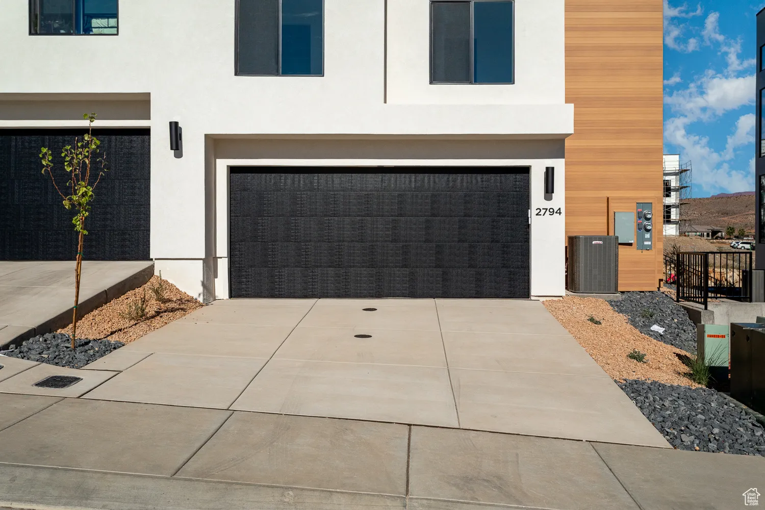 Contemporary house with an attached garage, stucco siding, and concrete driveway