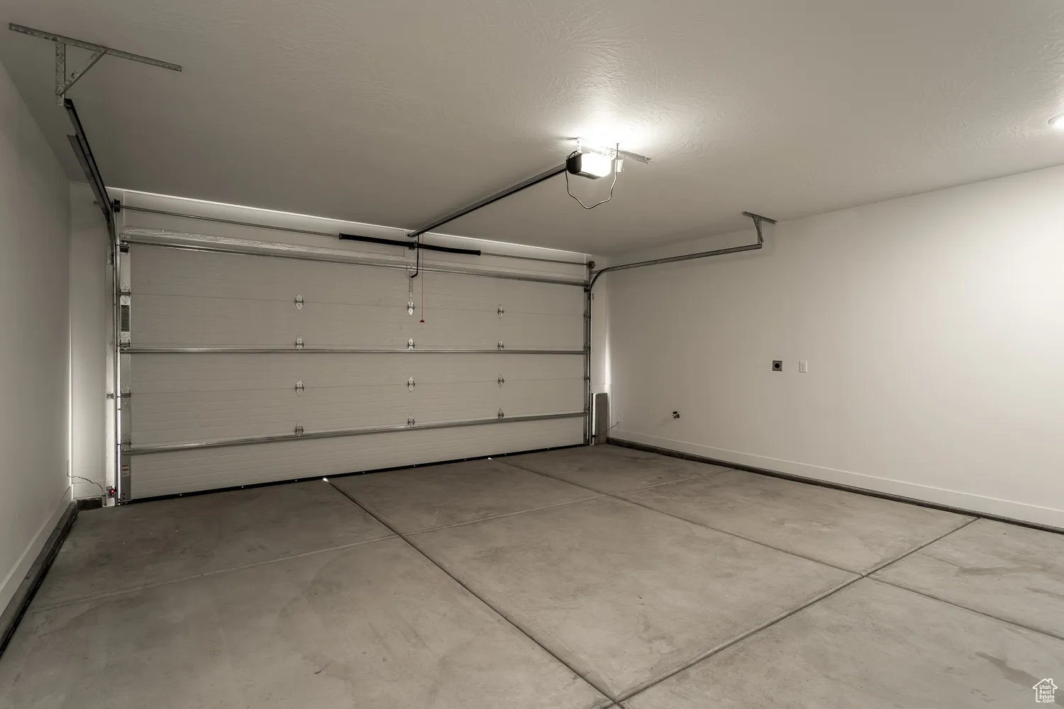 Garage with baseboards and a garage door opener