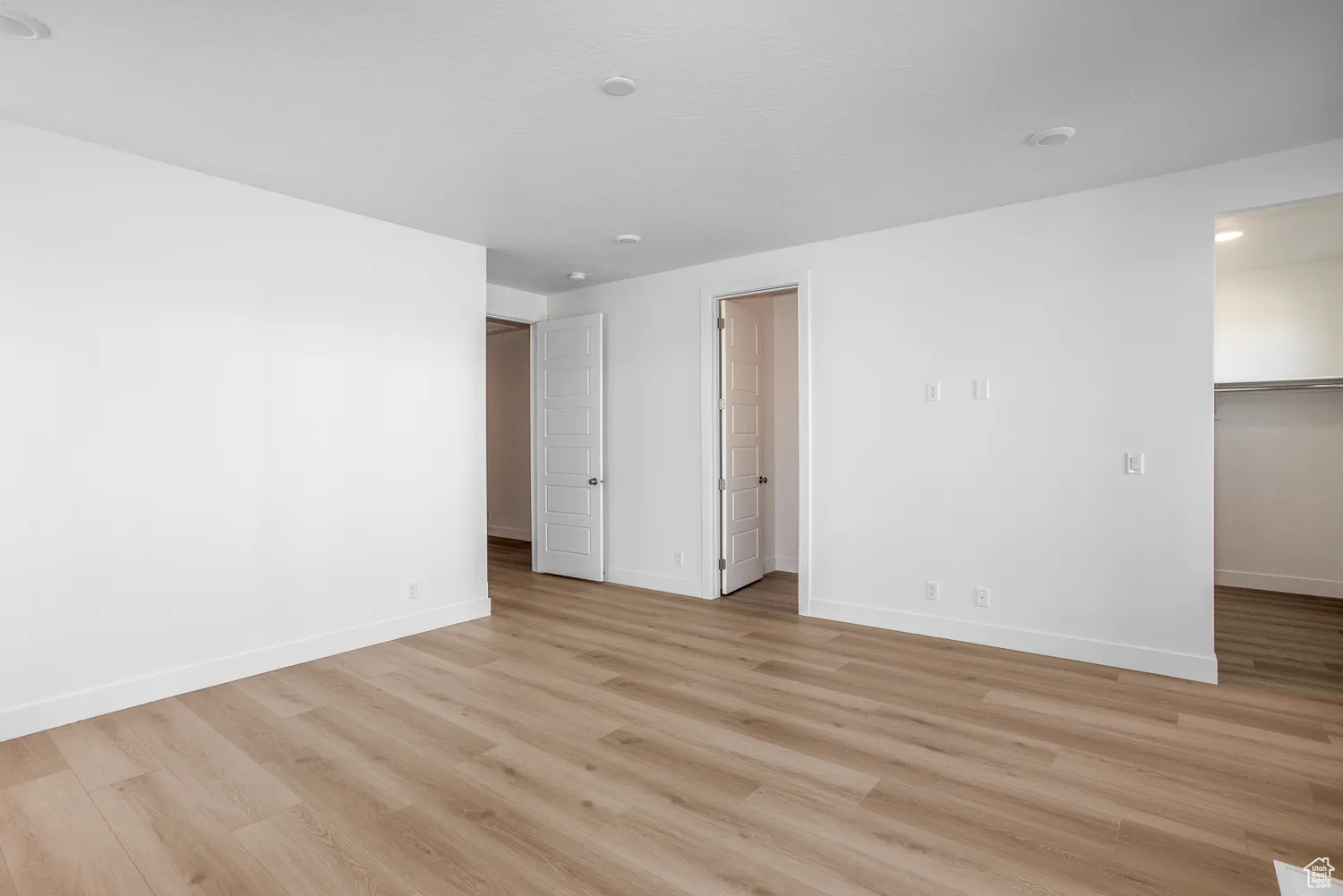 Empty room with light wood-style floors and baseboards