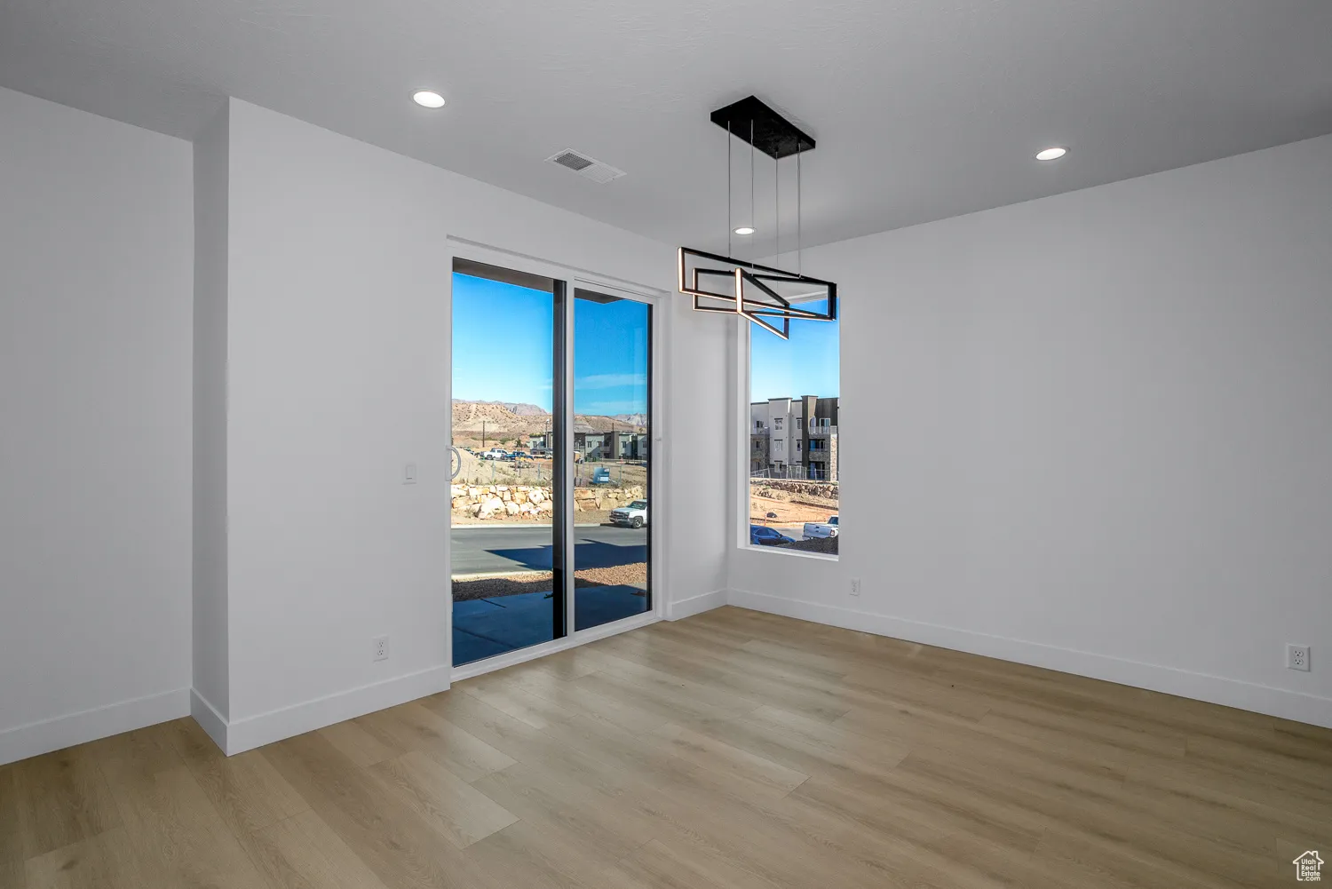 Unfurnished dining area with light wood-style floors, recessed lighting, and a chandelier