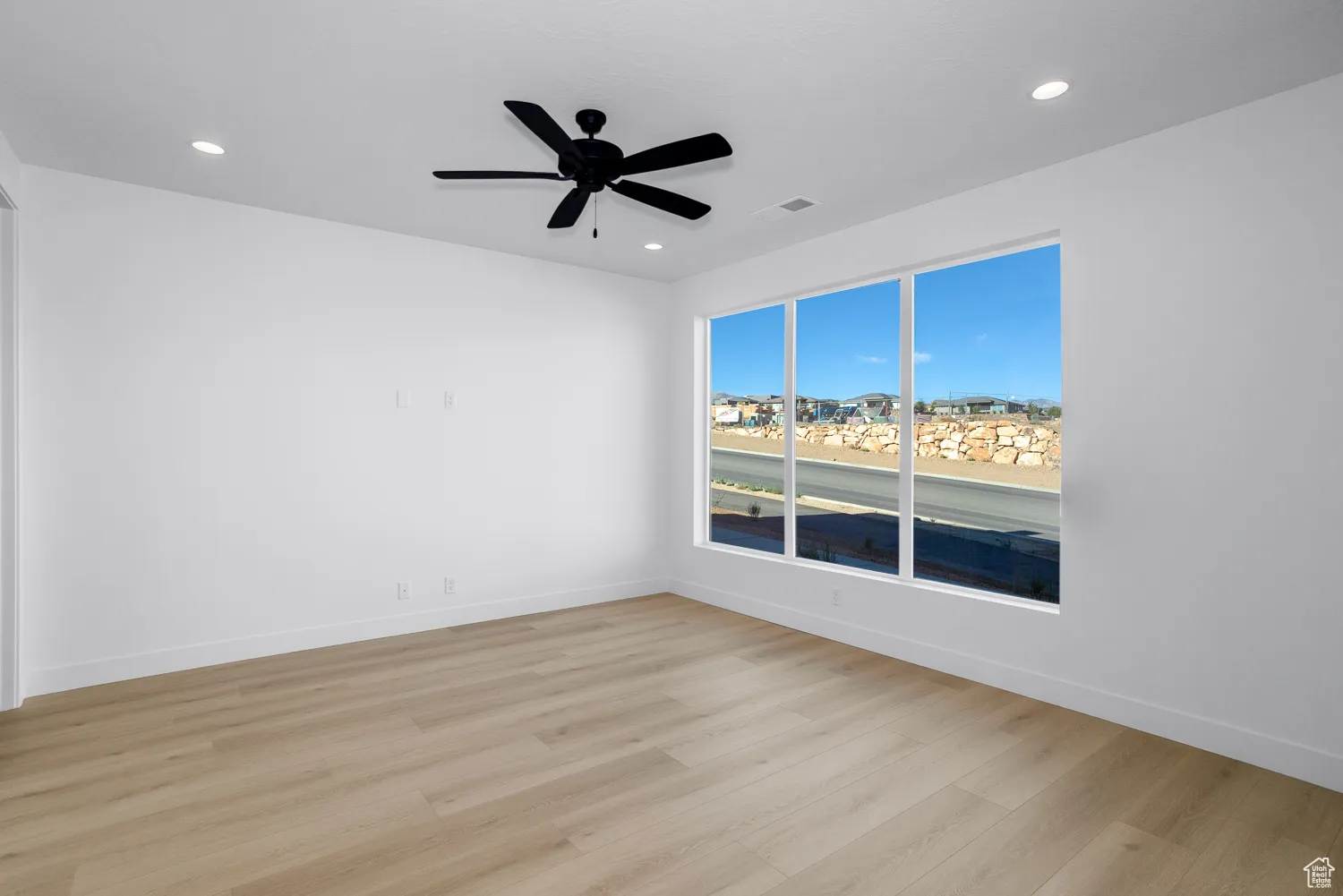Spare room with light wood-style flooring, a ceiling fan, recessed lighting, and a residential view