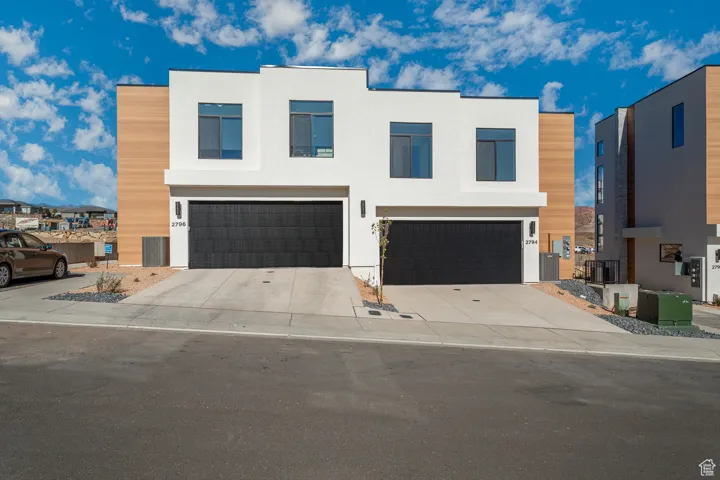 Contemporary home with stucco siding, concrete driveway, and an attached garage
