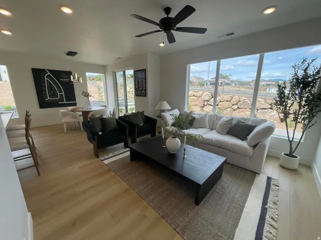Recessed lighting, wood-finish flooring, ceiling fan, expansive windows, and a sliding glass door