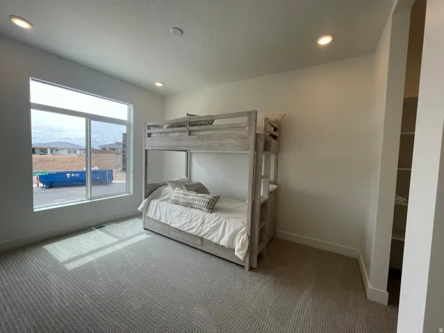 Recessed lighting, large window, carpeted flooring, and built-in shelving