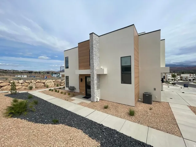 Modern stucco exterior with wood-finish panel accents and stone detailing