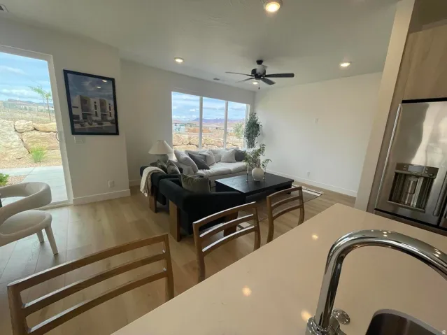 Open-concept living space featuring wood-finish flooring, recessed lighting, and expansive windows