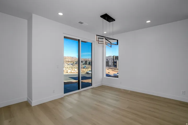 Wood-finish flooring with white walls and recessed lighting
