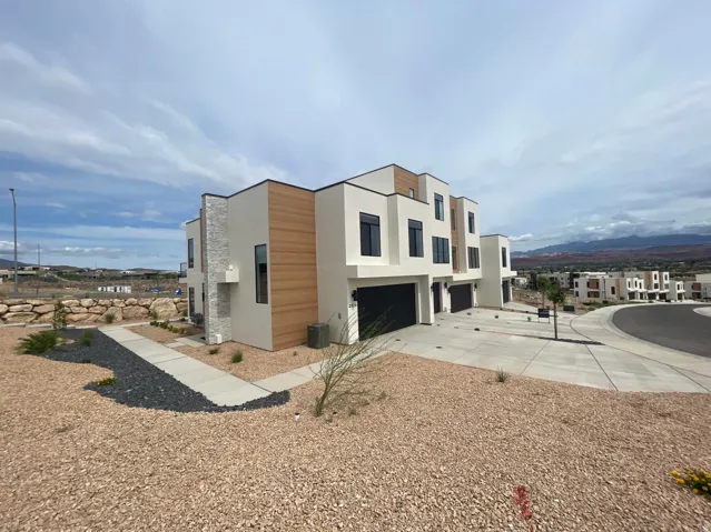 Modern stucco exterior featuring wood-finish siding and stone accents