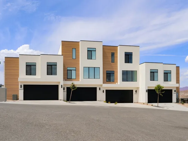 Modern architectural design featuring light-colored stucco and wood-finish siding
