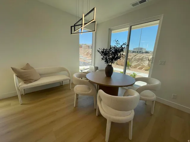 Recessed lighting, wood-finish flooring, and a modern linear chandelier