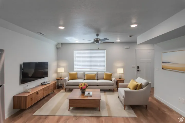 Living area with LVT flooring, recessed lighting, and ceiling fan