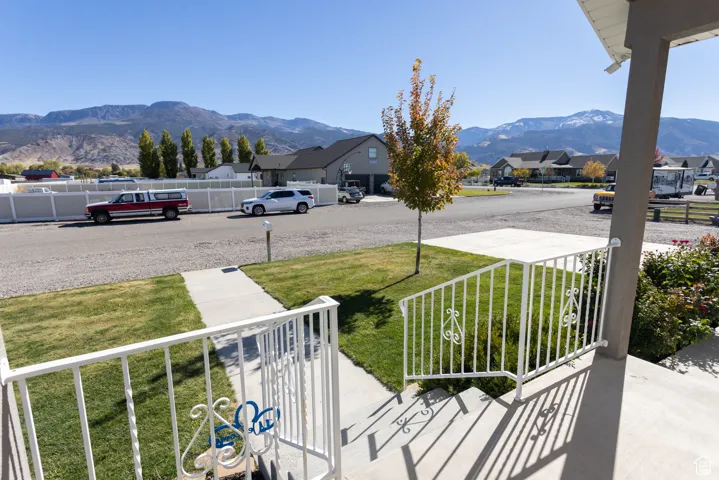 Covered porch featuring a mountain view and a residential view