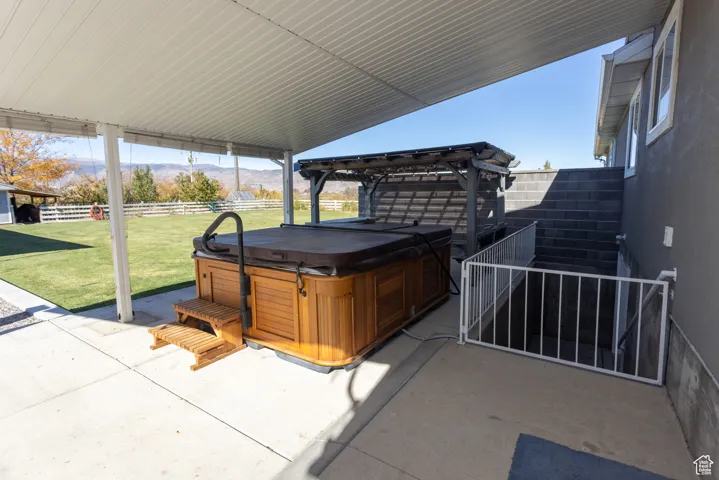 View of patio featuring a hot tub, a mountain view, and a pergola