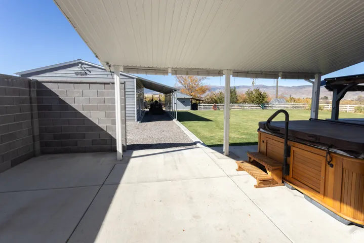 View of patio featuring a mountain view and a hot tub