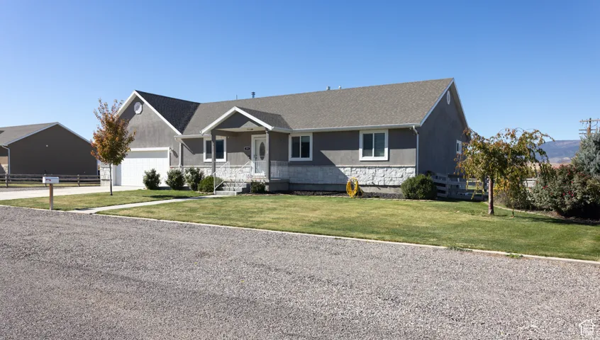 Ranch-style house with a front yard, driveway, and a shingled roof