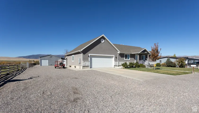 Single story home featuring stucco siding, concrete driveway, and a mountain view