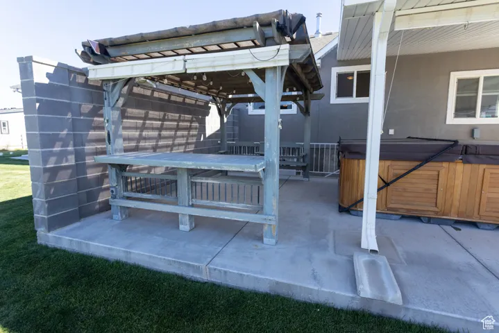 View of patio / terrace with a hot tub, outdoor dining area, and a gazebo