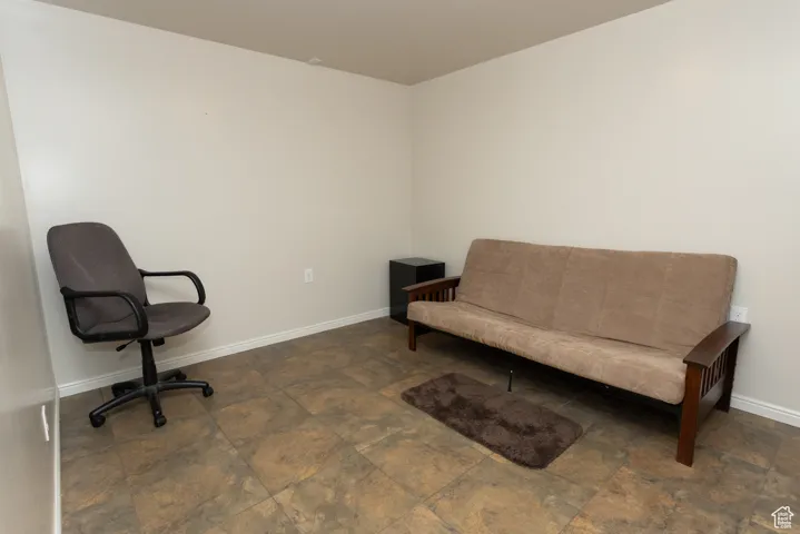 Living area with baseboards and stone finish floors