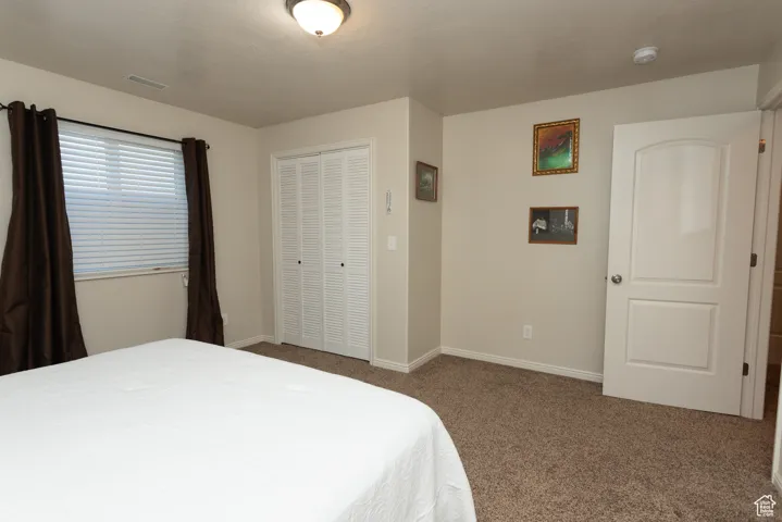 Bedroom featuring carpet and a closet