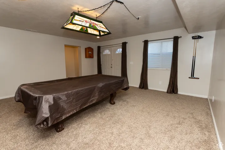 Game room featuring billiards, light carpet, and a textured ceiling