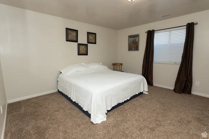 Bedroom featuring carpet flooring and baseboards
