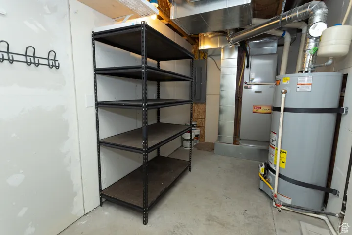 Unfinished below grade area featuring secured water heater and electric panel