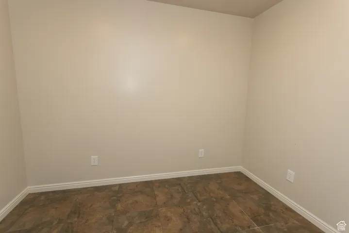 Spare room with baseboards and stone finish flooring