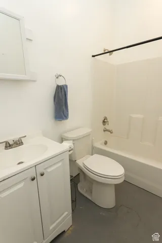 Bathroom with concrete flooring, vanity, and shower / bath combination