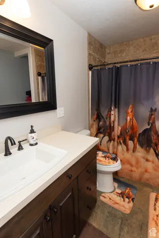Full bathroom featuring vanity, a shower with shower curtain, and a textured ceiling