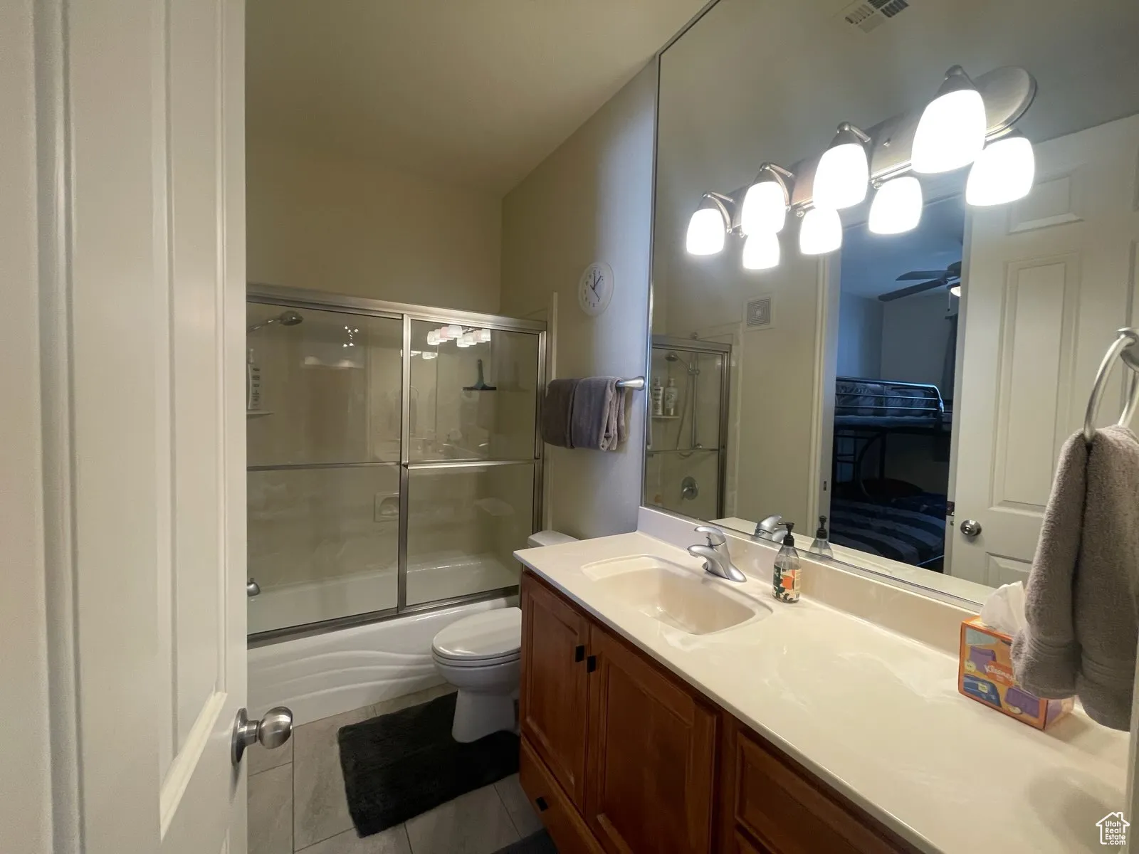 bathroom #2 the vanity, enclosed tub / shower combo, and tile patterned floors
