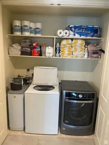 Laundry room featuring independent washer and dryer and light tile patterned flooring