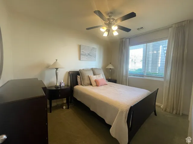 Carpeted bedroom featuring a ceiling fan