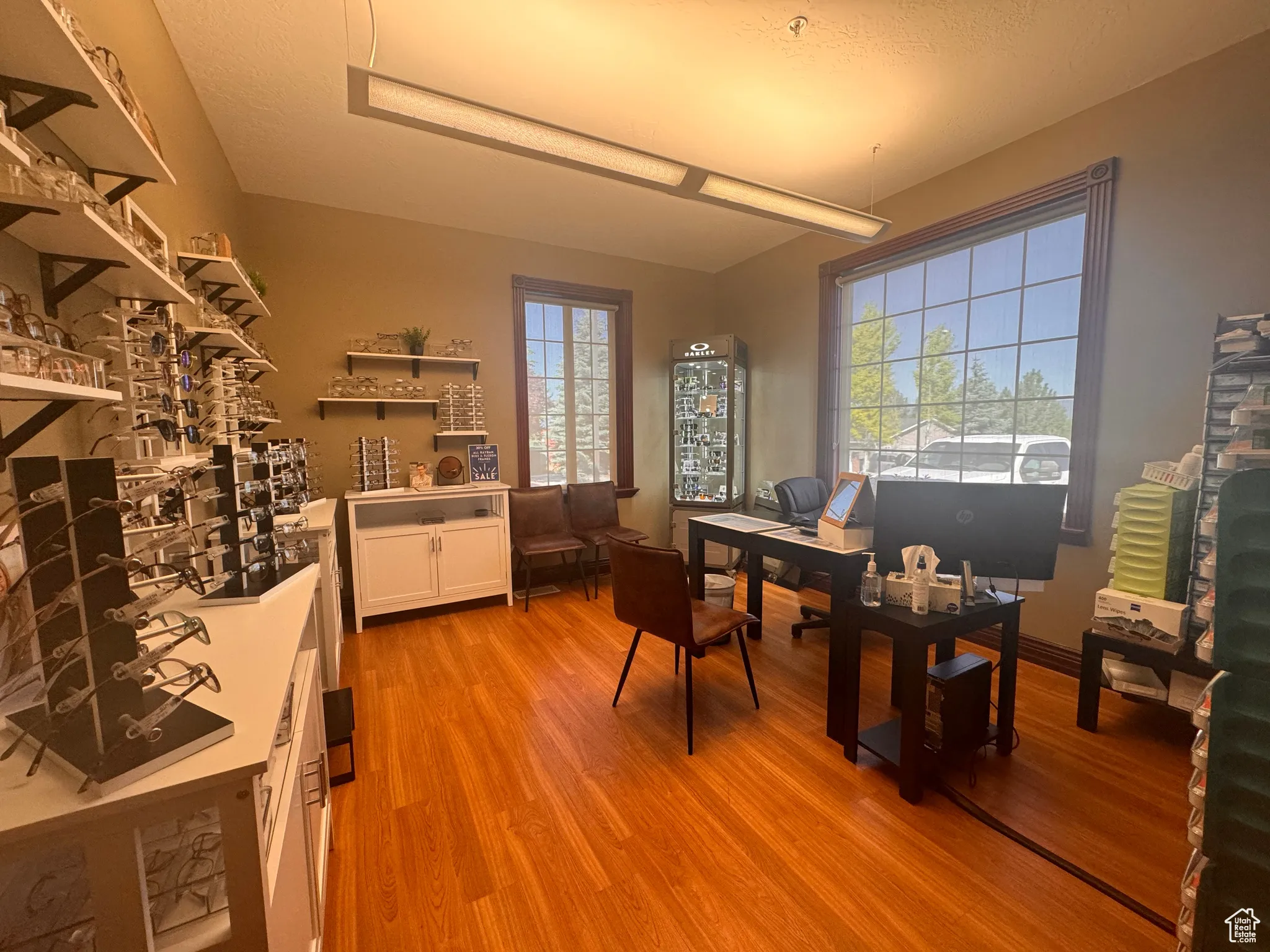 Office with light wood-style flooring and a textured ceiling