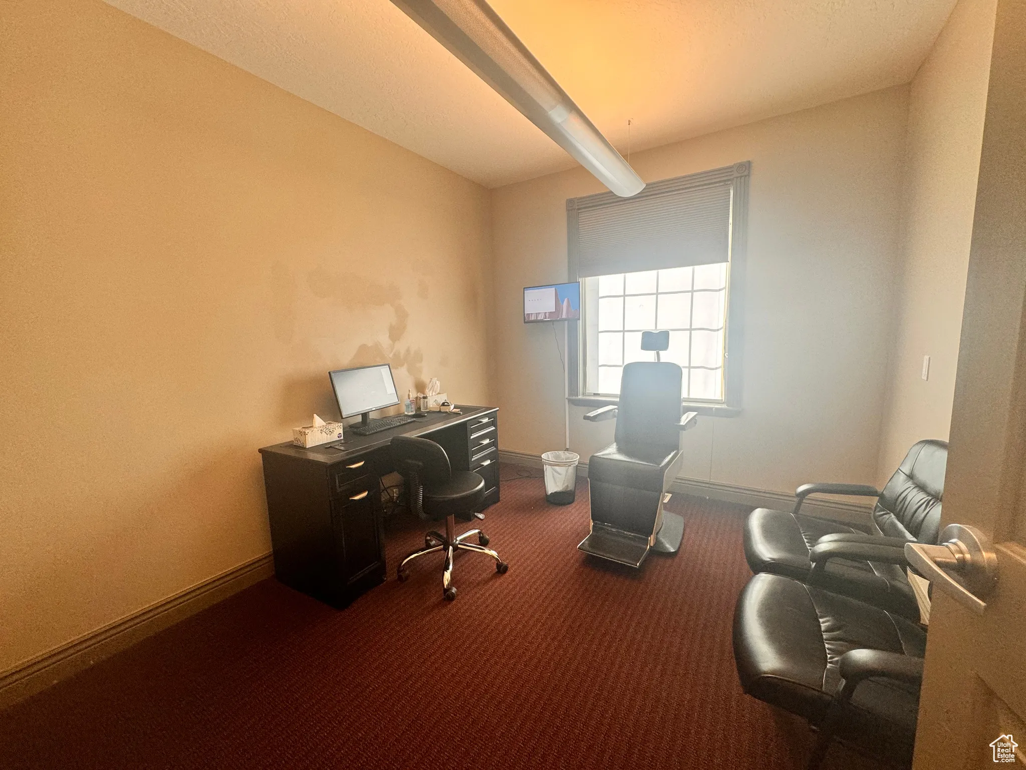 Office space featuring beam ceiling and dark colored carpet