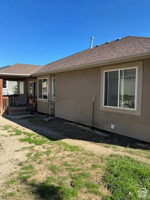 Rear view of property with a wooden deck and stucco siding