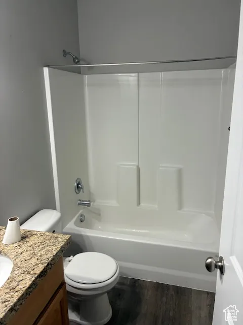 Bathroom featuring dark wood-style floors, shower / bathtub combination, and vanity
