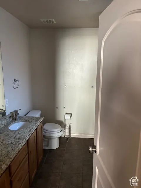 Bathroom featuring vanity and dark tile patterned flooring