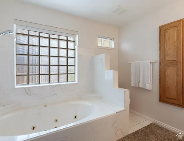 Bathroom featuring a jetted tub and light tile patterned flooring
